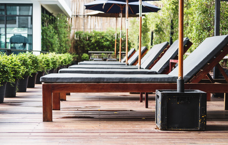 Luxury outdoor sunbathing deck chair at resort swimming poolの写真素材