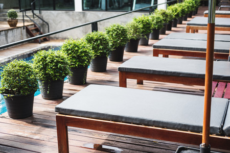 Luxury outdoor sunbathing deck chair at resort swimming poolの写真素材