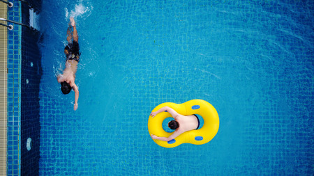 Top view, people relaxing in swimming poolの写真素材