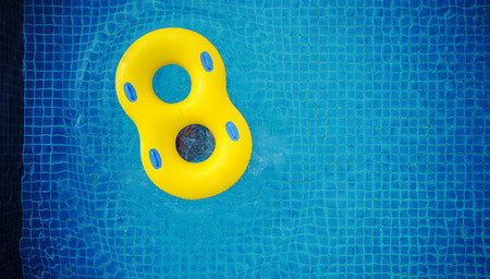 Yellow swim pool float, floating in swimming poolの写真素材