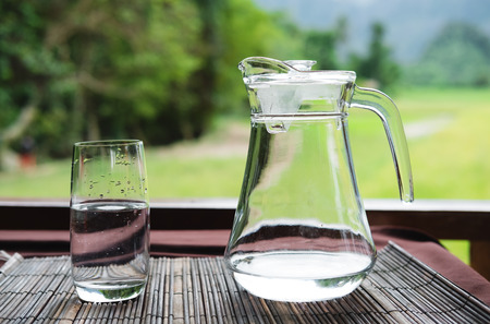 Pitcher and glass of water on tableの写真素材