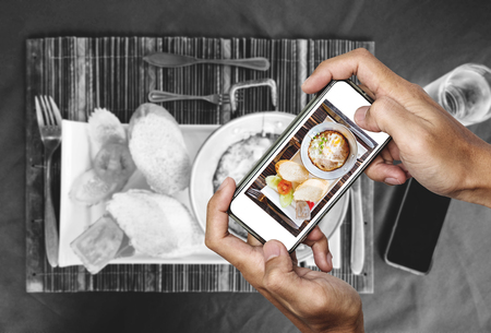 Taking food photography of homemade pan eggs fried and toasted bread, top view by smart phone, black and white backgroundsの写真素材