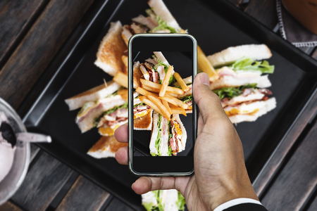 Taking photo of club sandwich, top view by mobile smart phoneの写真素材