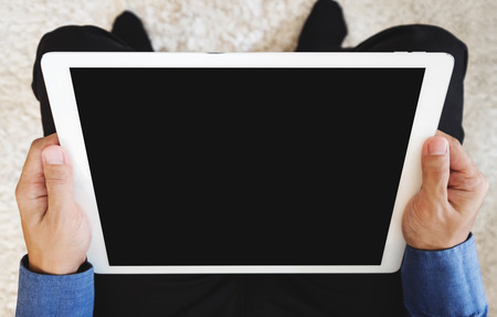a man in blue shirt holding digital tablet computer, clipping path empty black screenの写真素材