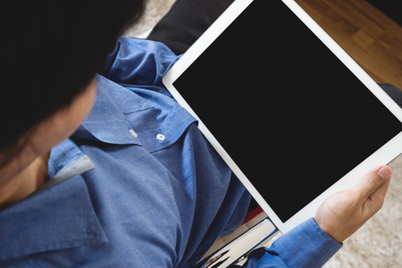 a man in blue shirt holding digital tablet computer, clipping path empty black screenの写真素材