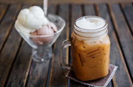 Iced Coffee with Ice Creams on wooden table, selective focus on Coffee Cup, Summer Dessertの写真素材