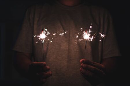 hands holding sparklers fireworkの写真素材