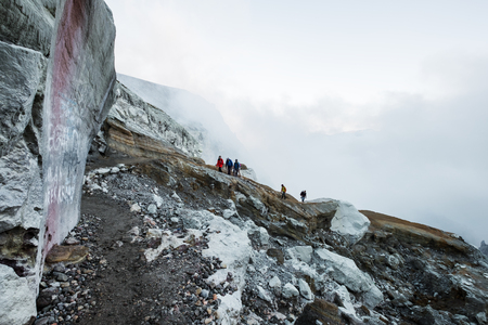 Group of young travelers walking on volcanic mountain, Kawah Ijen crater in Indonesiaのeditorial素材