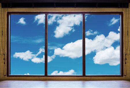 Looking through window, wooden window frames with blue sky and white clouds viewの写真素材