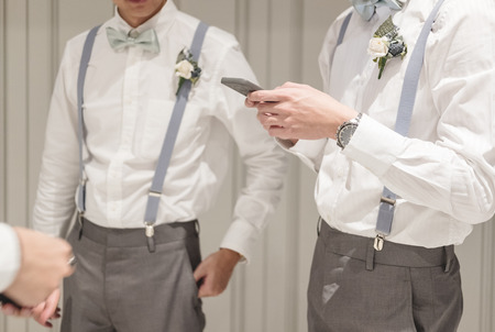 two friends in formal clothing standing talking together, best man