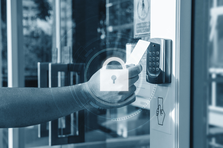 Hand using security key card scanning open the door to entering private building with lock icon...