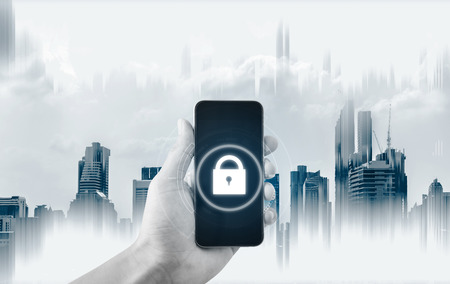 Mobile security system . Hand holding mobile smart phone with lock icon on screen