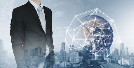 Global network and international global business. Double exposure businessman and city background with global network connection hologram technology. Element of this image are furnished by NASAの写真素材