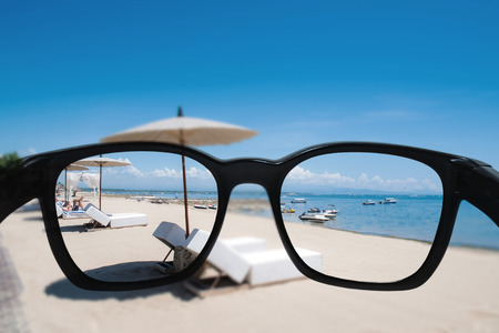 Summer holiday and vacation. Looking through sunglasses lens to beautiful beach in summerの写真素材