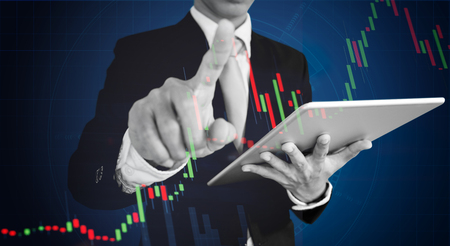 Businessman pointing finger on graph diagram. Business growth, investment and finance conceptの写真素材