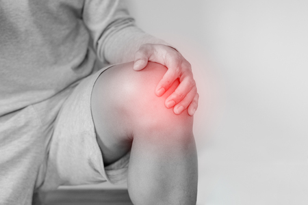 Knee joint pain, a man touching knee and suffering from knee painの写真素材