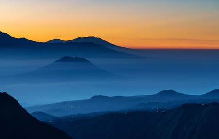 Mountain range landscape and silhouette mountains with colourful fog in sunriseの写真素材