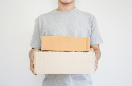 Deliveryman holding parcel boxes package, on white backgroundの写真素材