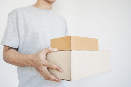 Deliveryman holding parcel boxes package, on white backgroundの写真素材