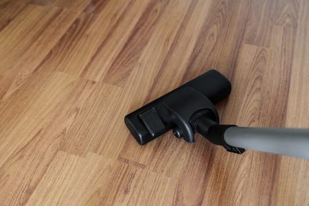 Cleaning laminate wood floor, vacuum cleaner cleaning dust and dirtinessの写真素材