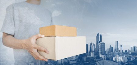 a man holding parcel boxes package, with Bangkok city backgroundのeditorial素材