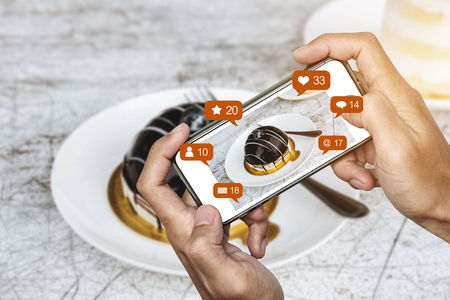 Taking dessert photograph by mobile smart phone, and sharing on social media, social network with notification iconsの写真素材