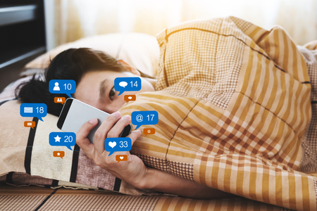 a man checking social media and social network after waking up in the morningの写真素材