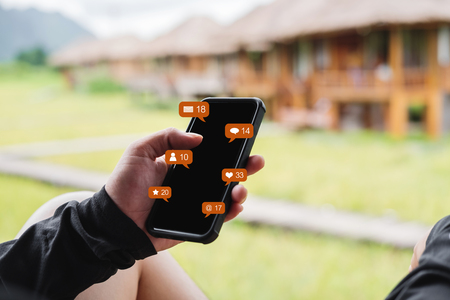 a man using mobile phone with social media and online message notification iconsの写真素材