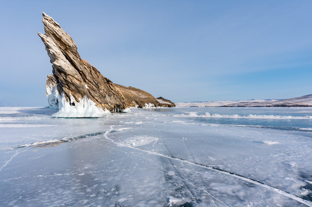 Winter landscape, cracked frozen lake with beautiful mountain island on frozen lake Baikal in Siberia, Russiaの写真素材