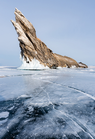 Winter landscape, cracked frozen lake with beautiful mountain island on frozen lake Baikal in Siberia, Russiaの写真素材
