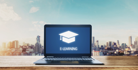 E-learning on computer laptop and city sunrise background. Online education, e-learning and e-book conceptの写真素材