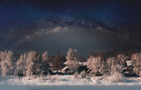 Winter landscape, forest covered by snow with sky full of starsの写真素材