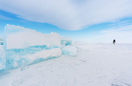 Travelling in winter, a man walking on frozen lake Baikal in winter