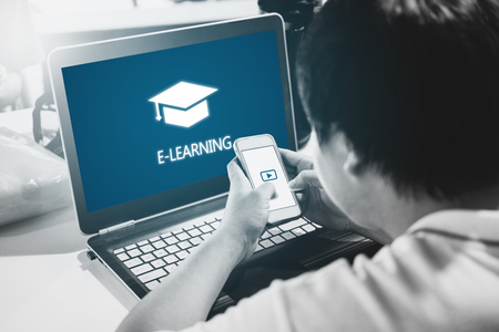 Online education, e-learning and e-book concept. a man using computer laptop and mobile smart phone for education at homeの写真素材