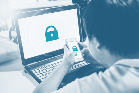 Network and internet devices security system. a man using mobile phone and computer laptop with lock icon technology on screenの写真素材