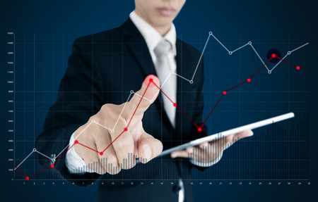Businessman pointing raising graph on screen. Business growth, investment and finance conceptの写真素材
