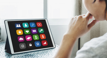 Online media and application technology on digital tablet. a man using online media application on digital tabletの写真素材