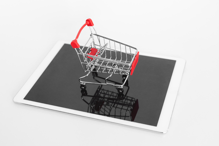 Empty shopping cart on digital tablet, isolated on white background. Online shoppingの写真素材