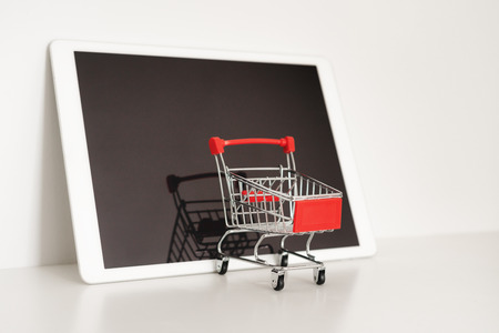 Empty shopping cart on digital tablet,  on white background. Online shoppingの写真素材