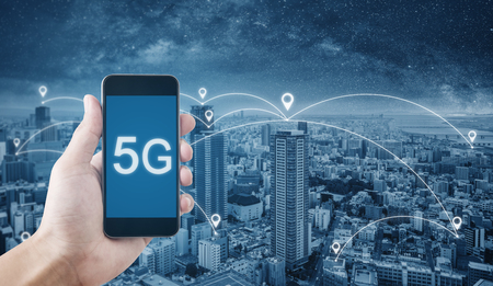 5G technology, Hand using 5g internet on mobile smartphone and city with networkingの写真素材