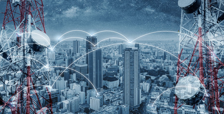 Networking and internet network technology in the city. Telecommunication towers with cityscape and networking linesの写真素材