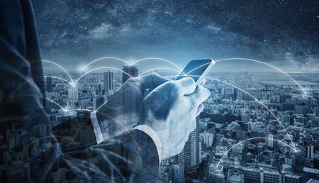 Double exposure businessman using mobile smart phone, and network connection technology in the city. Business network, blockchain technology and internet connectionの写真素材