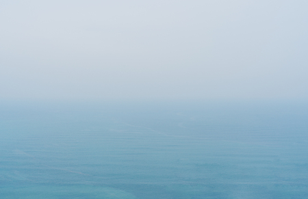 Blue sea with mist and overcast sky, mystery environment over oceanの写真素材