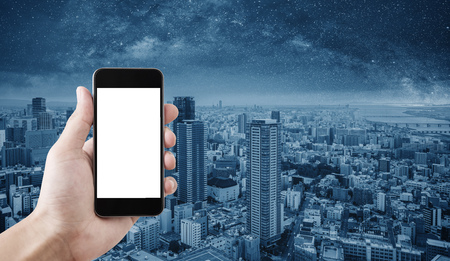 Hand holding mobile smart phone, empty white screen, Osaka city, Japan backgroundの写真素材