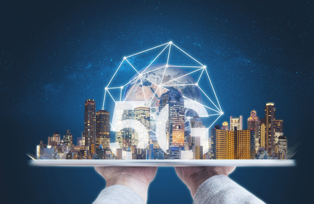 5G internet network and technology, Hand holding digital tablet with buildings and 5g network connection.の写真素材