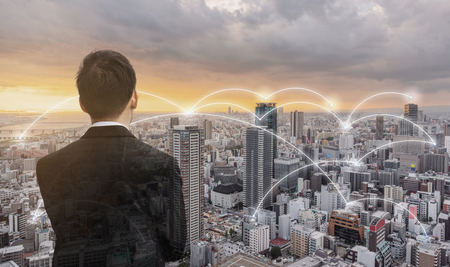 Network technology, logistics and blockchain business. Businessman looking city view in sunsetの写真素材