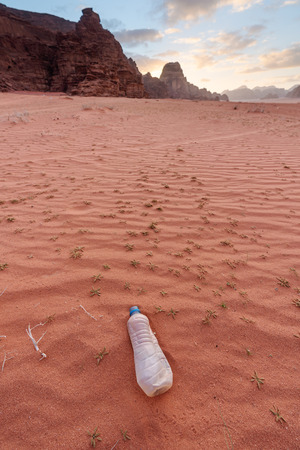 Plastic waste bottle on sand in desert. Environmental problem, plastic waste problems, and global warmingの写真素材