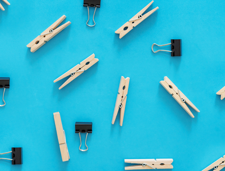 Binder clips and wooden clips on blue backgrounds