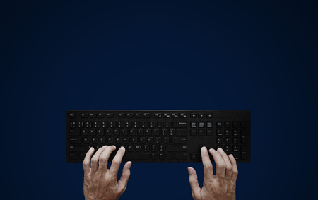 Top view, Hand typing computer keyboard on blue background