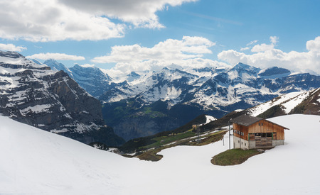 Panoramic Swiss Alps mountain range landscape with wooden cottage in Grindelwald, Switzerlandのeditorial素材